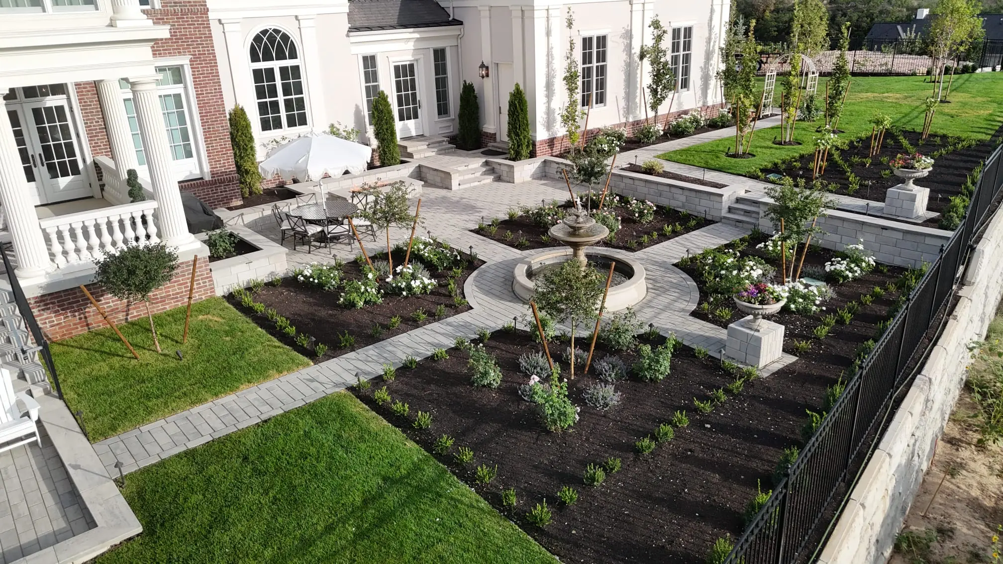Paver garden walkways and circular fountain patio surrounded by landscaped beds