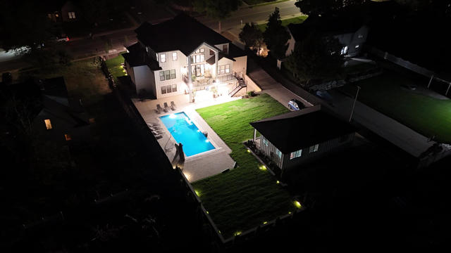 Night view of illuminated backyard pool