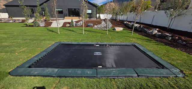 In-ground trampoline with landscaped backyard