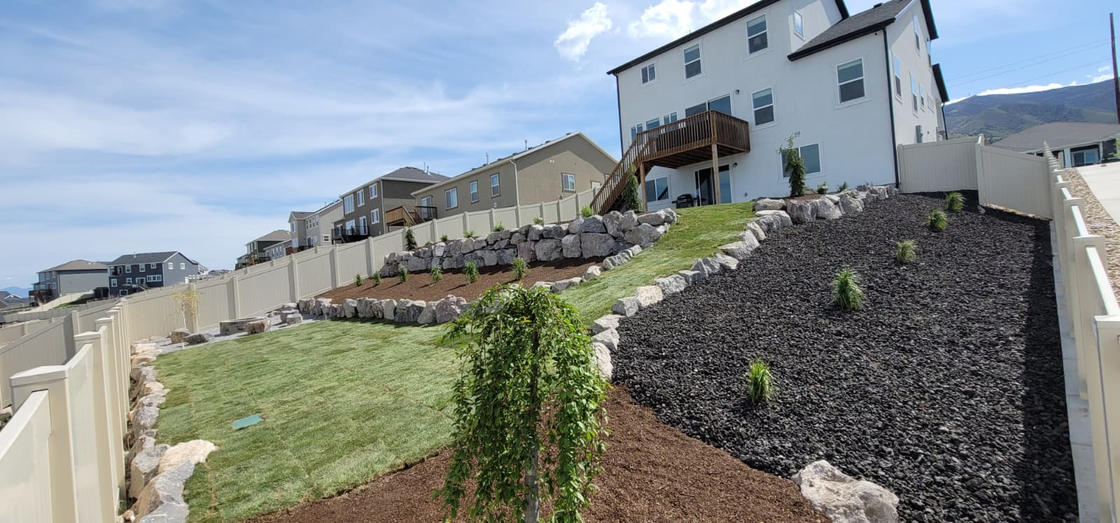 Boulder retaining wall with landscaping